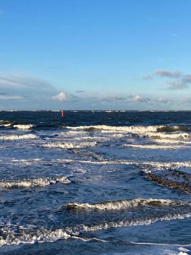 un grupo de pequeñas olas en el océano en Haus Naase App 3 en Norderney