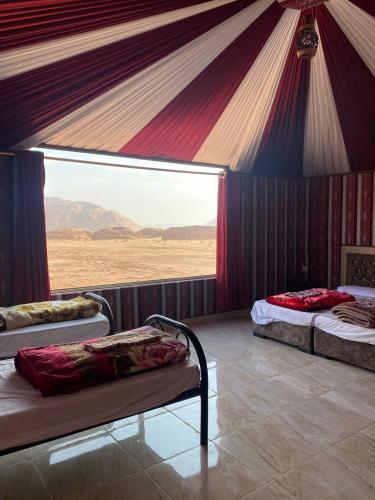 a room with three beds in a tent at Lucas Camp Wadi Rum in Disah