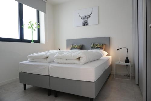 1 dormitorio blanco con 1 cama con sábanas blancas en Faro Greenpark APP 01, Cadzand-Bad, en Cadzand
