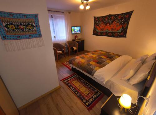 a bedroom with a bed and a living room at Poiana Sașilor - Valea Doftanei in Trăisteni