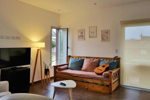 a living room with a couch with a guitar on it at Casa sobre la Colina in Mar del Plata