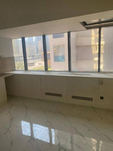 an empty room with windows and a marble floor at Studio near Burj khalifa (emirates tower metro station) in Dubai