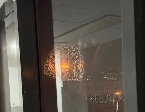 a glass window with a reflection of a ball in it at Studio near Burj khalifa (emirates tower metro station) in Dubai