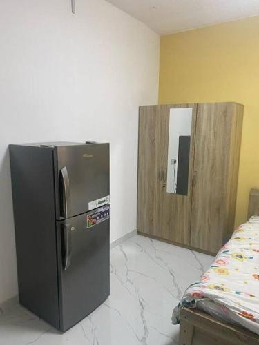 a black refrigerator in a room with a mirror at Studio near Burj khalifa (emirates tower metro station) in Dubai