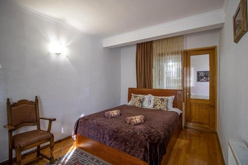 a bedroom with a bed and a chair in it at Cozy Apartment on Kostava in Tbilisi City