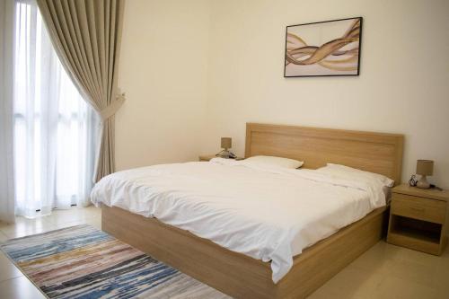 a bedroom with a large bed and a window at Your Silicon Oasis Escape-1bhk in Dubai