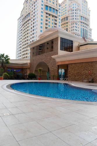 a building with a swimming pool in front of some buildings at Your Silicon Oasis Escape-1BHK in Dubai