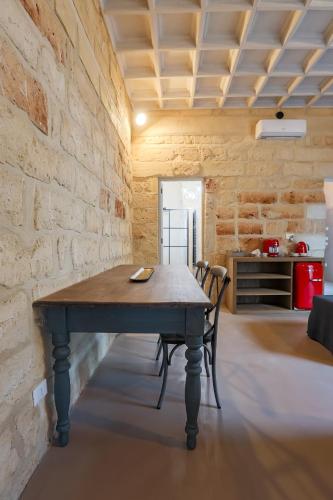 a table in a room with a brick wall at Palazzo Sant'Anna Lecce in Lecce