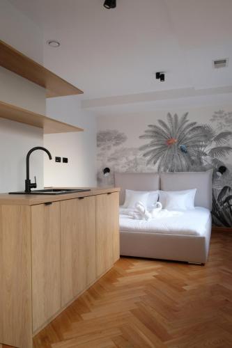 a bedroom with a bed and a kitchen with a sink at Sweet Dreams Apartments Bielsko-Biała in Bielsko-Biała