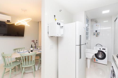 een keuken en eetkamer met een tafel en een koelkast bij Luxo em Ipanema 304 in Rio de Janeiro
