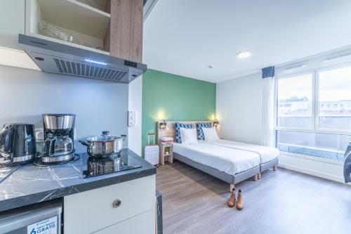 a kitchen and living room with a bed in a room at Break & Home Clermont-Ferrand Les Carmes Dechaux in Clermont-Ferrand