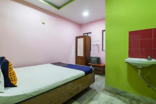 a bedroom with a bed and a sink in a room at Hotel O Bright in Jamshedpur