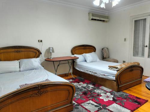 a bedroom with two beds and a dog laying on a rug at Dokki private home with 2 rooms WiFi Air-conditioning in Cairo