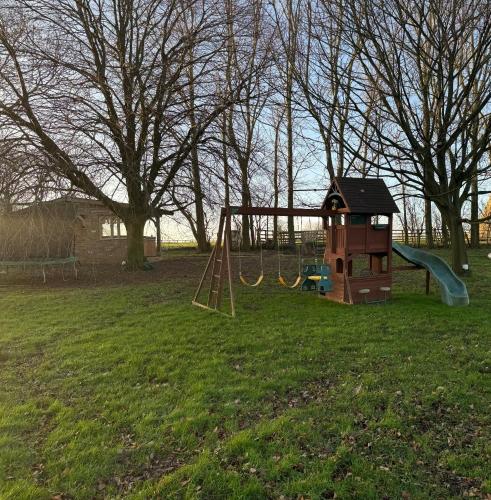 a park with a playground with a swing at Burtree Country House, Tipi's, Treehouse & Lodge & house rooms with hot tubs in a private garden in Thirsk