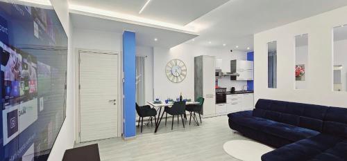 uma sala de estar com um sofá azul e uma mesa em Garibaldi Superior Apartment - Enjoy Your Life! em Faenza