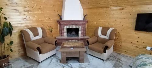 a living room with two chairs and a fireplace at Qusar-A-frame in Qusar