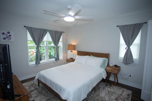 a bedroom with a white bed and a ceiling fan at New Townhome Near Downtown-King Bed/Workstation in Naperville