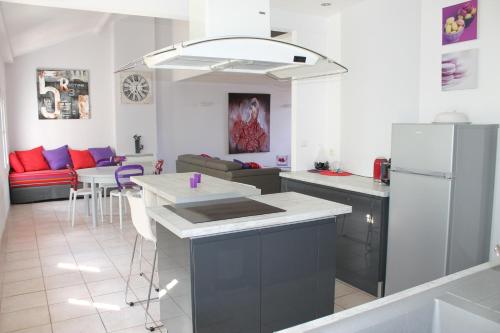 
a kitchen with a table and chairs and a refrigerator at Le Loft De La Robine in Narbonne
