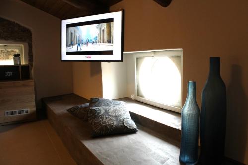 un soggiorno con TV, cuscino e finestra di Casa Rubini a Paestum