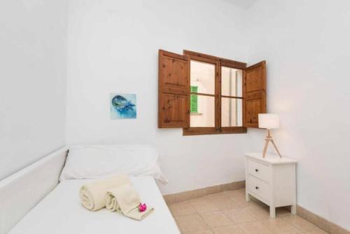 een witte slaapkamer met een bed en een raam bij Maca Plaza in Campanet