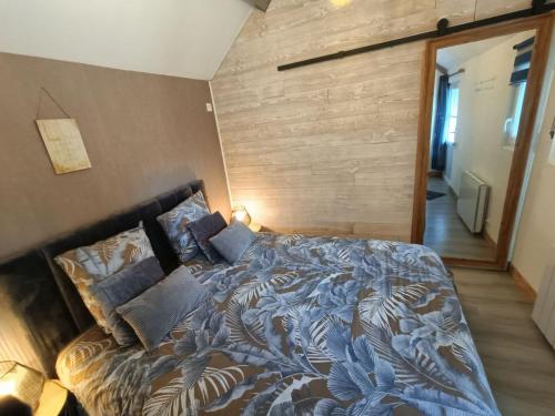 a bedroom with a large bed with a wooden wall at auxptitsbonheurs B&B in Saint-Jean-de-Monts