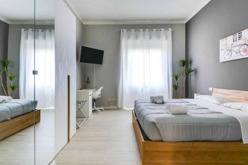 a bedroom with two beds and a desk in it at [The Garden] Centro Storico + Free Parking + Wi-Fi in Reggio Emilia