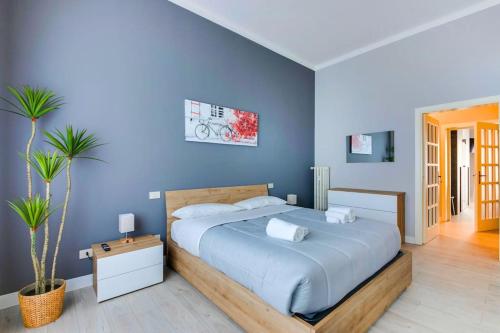a bedroom with a large bed with blue walls at [The Garden] Centro Storico + Free Parking + Wi-Fi in Reggio Emilia
