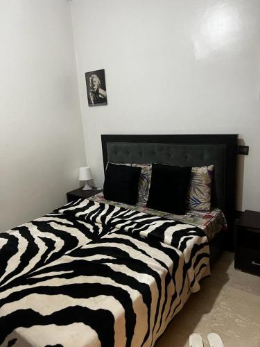 - un lit noir et blanc à imprimé zébré dans une chambre dans l'établissement Joli appartement centre Casablanca, à Casablanca