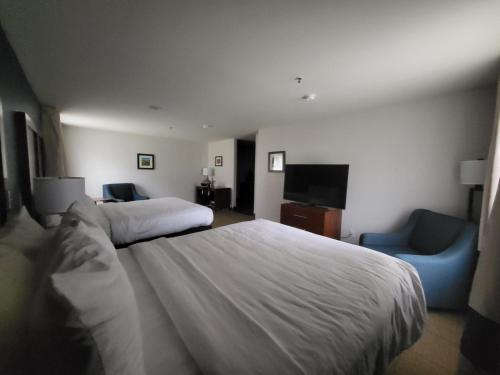 a hotel room with a large bed and a blue chair at Comfort Inn Somerset - Lake Cumberland in Somerset