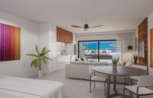a kitchen and a living room with a bed and a table at Aura Anse Marcel in Anse Marcel 