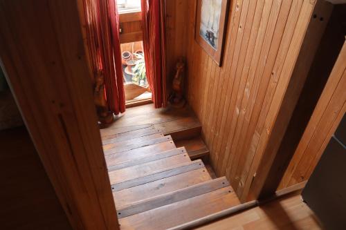 Una escalera de madera que conduce a una habitación con ventana en Casa infiernillo, en Pichilemu