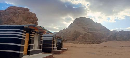 a group of buildings in the desert near the mountains at Wadi Rum Classic camp in Aqaba