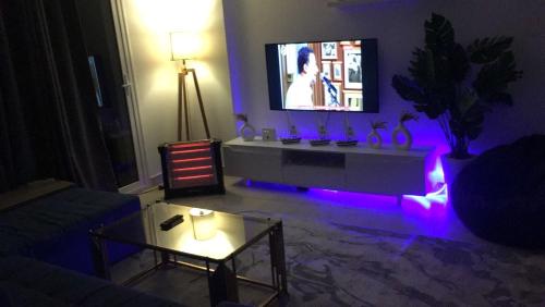 a living room with a tv and purple lights at Madinaty in Madinaty