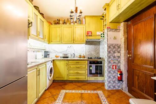 uma cozinha com armários amarelos e um forno com placa de fogão em House CONTU1000 no Porto