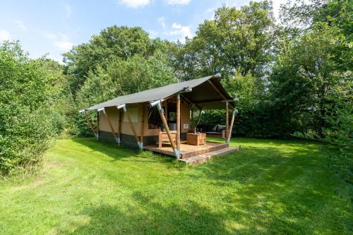 a gazebo in a field with trees at Safari tent 2 op Wellness Camping en B&B Stoltenborg in Meddoo