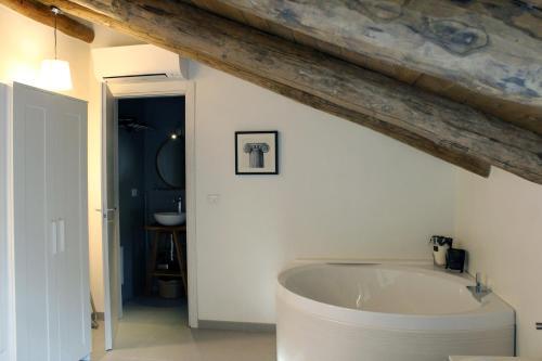 bagno con vasca bianca e soffitto in legno di Casa Rubini a Paestum