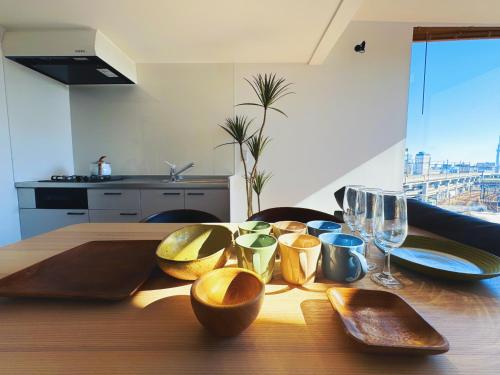 a wooden table with wooden bowls and wine glasses on it at 枕木 New house with Huge View for Family-Group in Tokyo