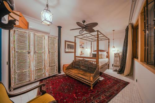 ein Schlafzimmer mit einem Bett, einem Spiegel und einem Stuhl in der Unterkunft Riad Tibibt in Marrakesch