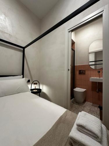 a bedroom with a bed and a bathroom with a tub at Cunabu Apartments in Rome
