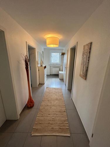 a hallway with a rug on the floor and a vase at Kragemann Hotel & Vinothek in Simmerath