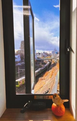 a bird sitting on an orange in front of a window at 枕木 New house with Huge View for Family-Group in Tokyo