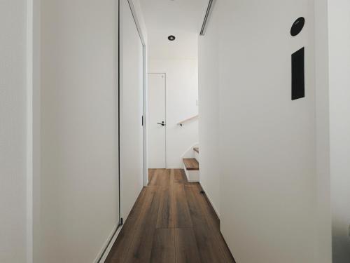 a hallway of a house with white walls and wood floors at 枕木 New house with Huge View for Family-Group in Tokyo