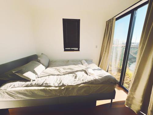 a bed in a room with a large window at 枕木 New house with Huge View for Family-Group in Tokyo