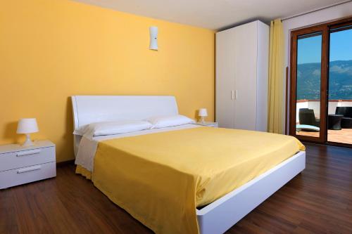 una camera da letto con un grande letto con una parete gialla di Bed And Breakfast Sunflower a Vico Equense
