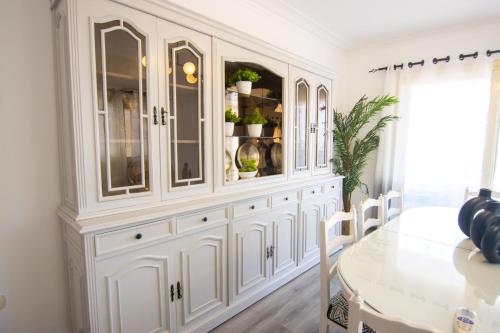 a white dining room cabinet with plants on it at Lovely 3BR Apartment in Heart of Mohandseen in Cairo