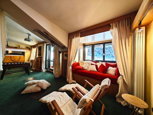 a living room with a red couch and chairs at Hostdomus - 007 Luxury Suites in Sestriere