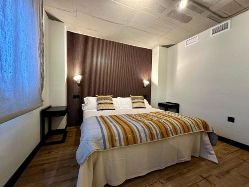 een slaapkamer met een groot bed met 2 kussens bij Bubu - Nuevo edificio de apartamentos en el centro in Málaga