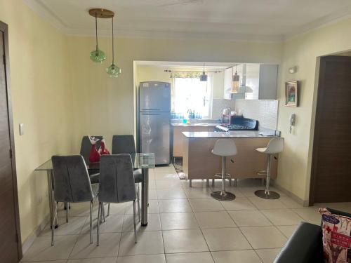 La cuisine est équipée d'une table, de chaises et d'un réfrigérateur. dans l'établissement Apartment near Airport & beach security 24/7, à La Cana
