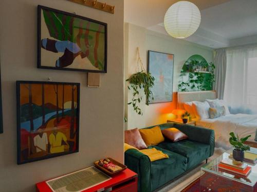 a living room with a green couch and a bed at Bohemian Studio Home in Nairobi Kilimani in Nairobi