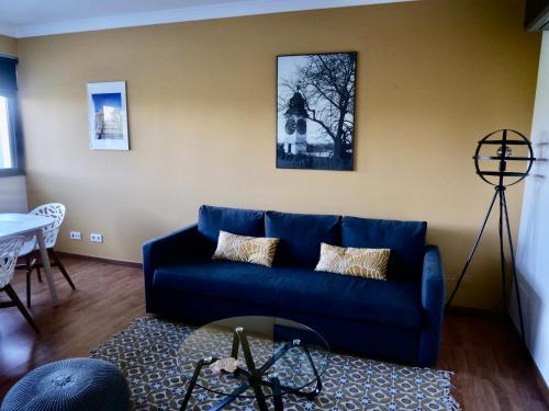 a living room with a blue couch and a table at casalonne in Tavira
